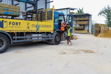 FORT yard employee helping FORT driver out of branded truck. Big smiles on faces, team work.