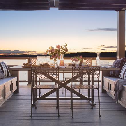 A beautiful decking space with Clam Shell installed, set with a picturesque backdrop of the ocean.